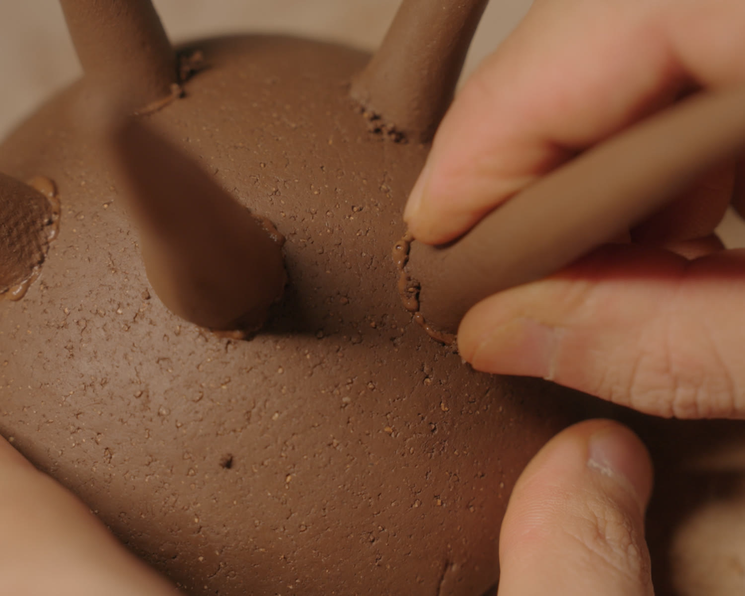 Close up of two hands pressing a spike into the scored wall of the bowl