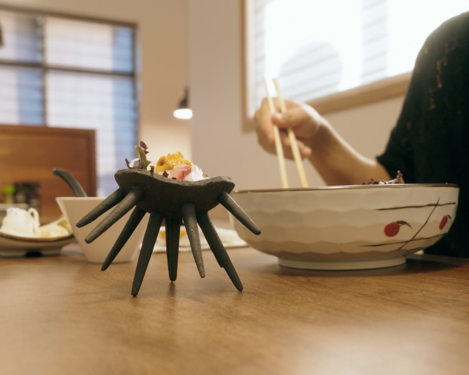 The finished bowl on a restaurant table, chopsticks reaching past it